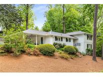 Charming one-story home with painted brick, landscaping, and mature trees, in a peaceful setting at 504 Kingswood Nw Ln, Atlanta, GA 30305