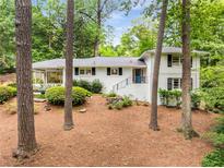 Charming white-painted brick home with a well-manicured lawn and inviting blue door at 504 Kingswood Nw Ln, Atlanta, GA 30305