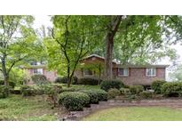 Charming brick home with mature trees and landscaping, offering a serene and inviting curb appeal at 1690 Cedar Grove Dr, Marietta, GA 30066