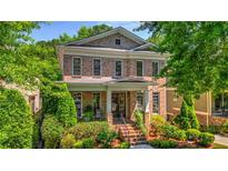 Charming brick home with a welcoming front porch, lush landscaping, and classic architectural details at 2043 Mason Mill Rd, Decatur, GA 30033