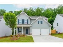 Charming two-story home with a well-manicured lawn, attached two car garage and stone accents at 174 Bloomfield Cir, Canton, GA 30114