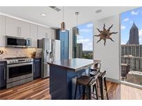 Modern kitchen with stainless steel appliances, island, and floor-to-ceiling windows offering city views at 860 Peachtree Ne St # 1712, Atlanta, GA 30308