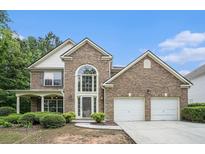 Charming brick home with a two-car garage and landscaped front yard offers great curb appeal at 7280 Wright Dr, Atlanta, GA 30349
