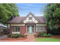 Charming Tudor home with brick facade, symmetrical windows, manicured landscaping and a tiled front walkway at 96 Dartmouth Ave, Avondale Estates, GA 30002