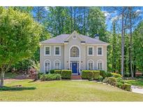 Charming two-story home with lush landscaping and a well-manicured lawn at 222 Mossy Pl, Alpharetta, GA 30005