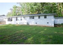 Charming white brick ranch-style home with lush front lawn and manicured landscaping at 345 Forest Valley Rd, Lawrenceville, GA 30046