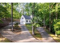 Charming two-story home with a manicured yard and a long driveway through a wooded area at 7240 Highbrook Cir, Cumming, GA 30041
