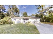 Charming single-story home featuring a well-maintained lawn, attached two car garage and inviting front porch at 3512 Valley Chase Ct, Lithonia, GA 30038