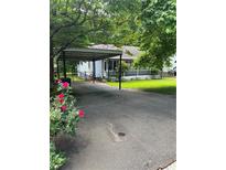 Charming home featuring a covered carport and cozy front porch, surrounded by lush greenery at 167 Mathews Se Cir, Marietta, GA 30067