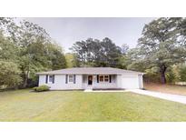 Charming single-story home with gray paint, complemented by a lush green lawn at 7125 Puckett Sw St, Covington, GA 30014
