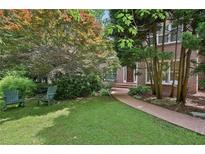Charming brick home with a lush front yard, walkway, and inviting rocking chairs at 1243 Williamswood Pointe, Decatur, GA 30033
