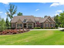 Beautiful brick and stone home featuring a well-manicured lawn, colorful flowers, and an elegant entrance at 341 Carl Sanders Dr, Acworth, GA 30101
