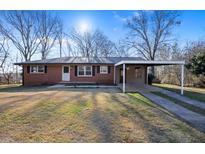 Charming brick home with a carport, lush lawn and classic design creating a welcoming curb appeal at 7427 Hollis Rd, Douglasville, GA 30135