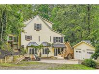 Charming two-story home with a lush green backdrop, a detached garage, and inviting front yard space at 510 Aiken Dr, Dallas, GA 30157