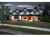 Stunning two-story home with black and white trim, well-manicured lawn, and a welcoming front porch at 320 Dodd Ln, Alpharetta, GA 30005