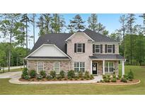 Beautiful two-story home featuring a combination of stone and brick, a dark roof, and a neatly landscaped front yard at 130 W Pier Way, Fayetteville, GA 30214