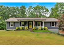 Charming single-story home featuring a welcoming front porch and well-maintained landscaped yard at 305 Devilla Trce, Fayetteville, GA 30214
