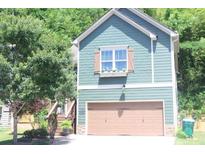 Charming home featuring green siding, a brown garage door, and a window box filled with flowers at 313 India Ln, Canton, GA 30114