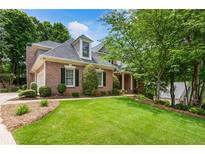 Charming brick home boasts a well-manicured lawn and lush landscaping, enhancing its curb appeal at 4561 Jenkins Way, Douglasville, GA 30135