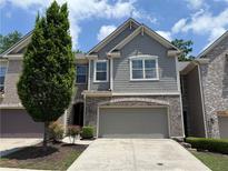 Charming two-story townhome with a neutral color scheme, two-car garage, and a well-maintained front yard at 1632 Lenox Overlook Ne Rd, Brookhaven, GA 30329