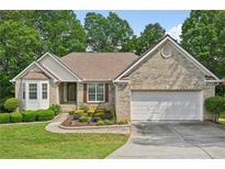 Charming brick home boasts a two-car garage and beautifully landscaped front yard at 3463 Dunbar Ln, Suwanee, GA 30024