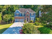 Charming two-story home with blue siding, brick accents, well-manicured lawn, and two-car garage at 111 Springshade Ln, Canton, GA 30114