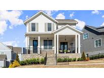 Charming two-story home featuring a welcoming front porch, stone accents, and professionally landscaped yard at 2005 Haley Walk, Woodstock, GA 30188