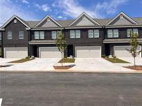New townhomes feature brick facades, a garage for each unit and well-manicured landscaping at 216 Eping Dr, Stockbridge, GA 30281