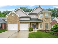 Charming two-story brick home with attached two-car garage and well-manicured lawn at 3492 Newtons Crest Cir, Snellville, GA 30078