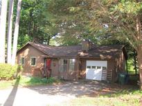 Charming single-story home featuring a garage, shingle siding, a red front door, and a well-maintained yard at 2494 Bronco Trl, Duluth, GA 30096