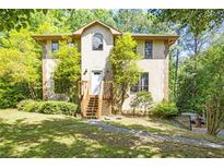 Inviting exterior featuring a stucco facade, wooden stairs leading to the front door, and lush landscaping at 1105 Mitchell Crossing Sw Dr, Atlanta, GA 30331