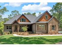 Charming home featuring a landscaped front yard, a combination of stone and wooden details, and a welcoming front porch at 33 Cedar Gate Ln, Kingston, GA 30145