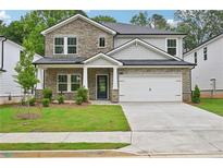 Inviting two-story home with stone accents, well-manicured lawn, and a two-car garage at 3974 Brushy St, Powder Springs, GA 30127