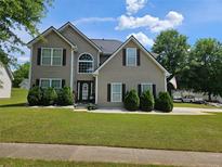 Inviting two-story home with manicured lawn and charming curb appeal under a beautiful sky at 4279 Persian Ct, Snellville, GA 30039