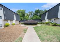 Attractive townhouse complex with manicured landscaping and a walkway on a sunny day at 5245 Chemin De Vie, Atlanta, GA 30342