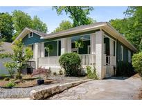 Charming bungalow featuring a quaint front porch, lush landscaping, and a welcoming curb appeal at 1545 Montreat Sw Pl, Atlanta, GA 30311