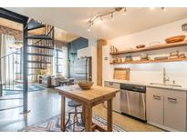 Modern kitchen featuring stainless steel appliances, open shelving, and a spiral staircase at 170 Boulevard Se # 521H, Atlanta, GA 30312