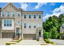 Beautiful townhome with a gray painted brick facade, two-car garage and charming architectural details at 2187 Elmont Se Way, Smyrna, GA 30080