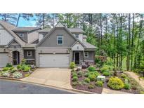 Charming townhome with a two-car garage and beautifully landscaped front yard at 232 Heron Pointe Vw, Canton, GA 30114