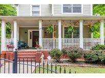 Inviting front porch featuring ferns, string lights, and classic white columns and railings at 380 Kendrick Se Ave, Atlanta, GA 30315