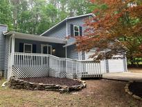 Charming two-story home with a covered front porch, white railings, and a two-car garage at 486 Victoria Rd, Woodstock, GA 30189