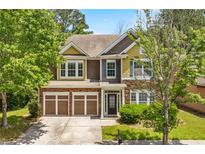 Charming two-story home featuring a two-car garage and beautifully landscaped front yard at 1125 Harvest Brook Way, Lawrenceville, GA 30043