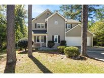 Inviting two-story home featuring neutral siding, dark shutters, and a well-maintained front yard at 1493 Martin Nash Sw Rd, Lilburn, GA 30047