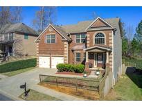 Charming two-story brick home with a well-manicured lawn, two car garage and inviting front porch at 7933 Heathmore Dr, Fairburn, GA 30213
