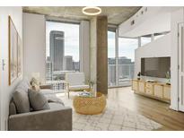 Bright living room featuring hardwood floors, large windows, and a comfortable seating area, perfect for relaxing and entertaining at 860 Peachtree Ne St # 2209, Atlanta, GA 30308