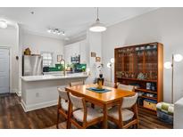 An open dining area features hardwood floors, a wood table with seating for six, and connects to the kitchen at 1635 Briarcliff Rd # 8, Atlanta, GA 30306