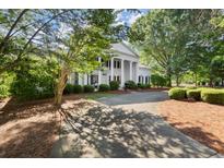 Stately home with white columns, black shutters, and a circular driveway surrounded by lush landscaping at 3818 Sweet Bottom Dr, Duluth, GA 30096