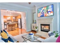 Inviting living room featuring a fireplace and an open view to the kitchen with bar seating at 11 Perimeter E Ctr # 1203, Dunwoody, GA 30346