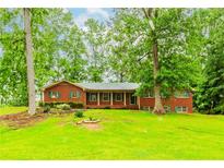 Charming brick ranch-style home with green shutters and a covered front porch on a spacious lot at 201 Smithstone Path, Fayetteville, GA 30214