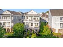 Charming three-story home featuring double balconies, a covered patio, and lush landscaping at 7120 Lullwater Rd, Cumming, GA 30040